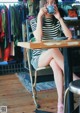 A woman sitting at a table with a cup of coffee.