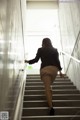 A woman walking up a set of stairs in a building.