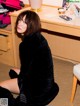 A woman sitting on the floor in front of a desk.